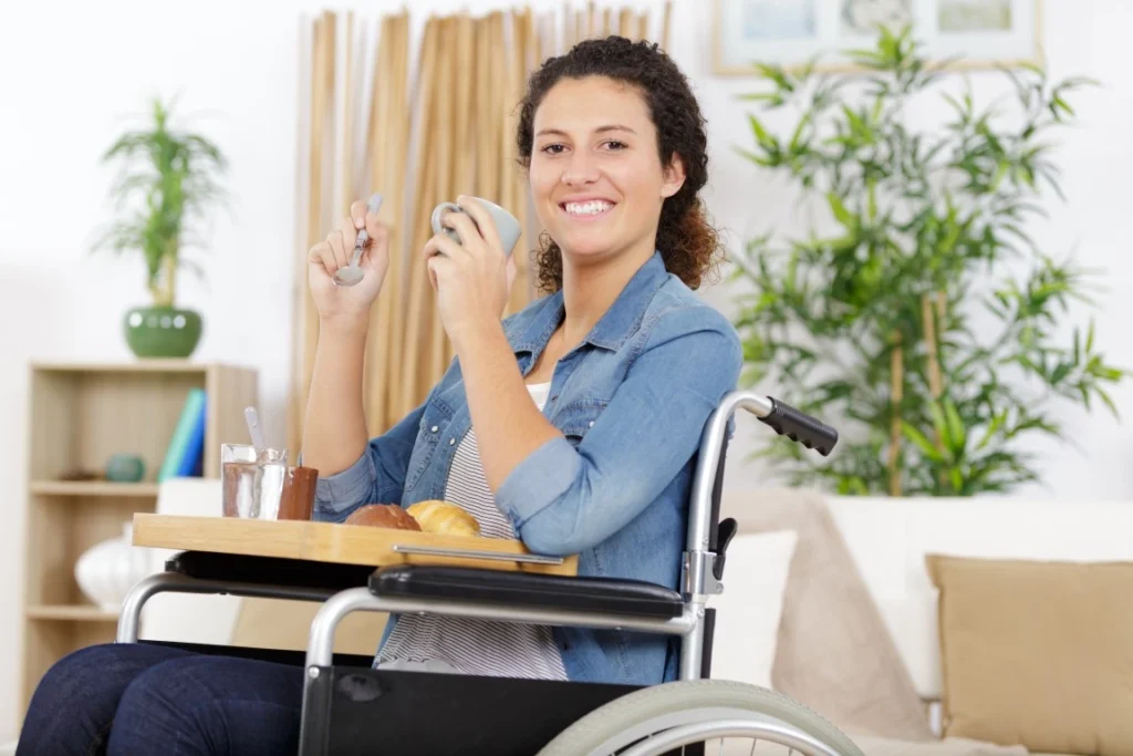 Woman in wheelchair eating breakfast and smiling at camera